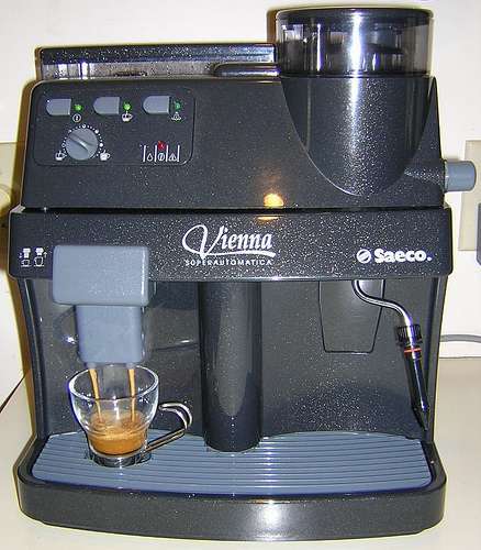 Black espresso machine with a glass cup.